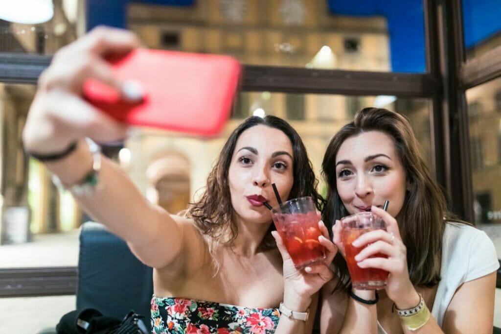Female couple out on date for cocktails taking a selfie
