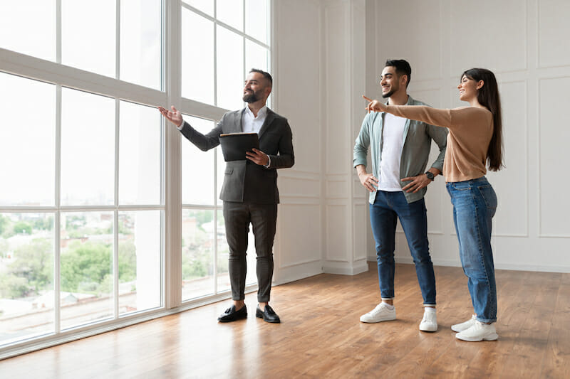 Male and female students viewing a new property with an estate agent 